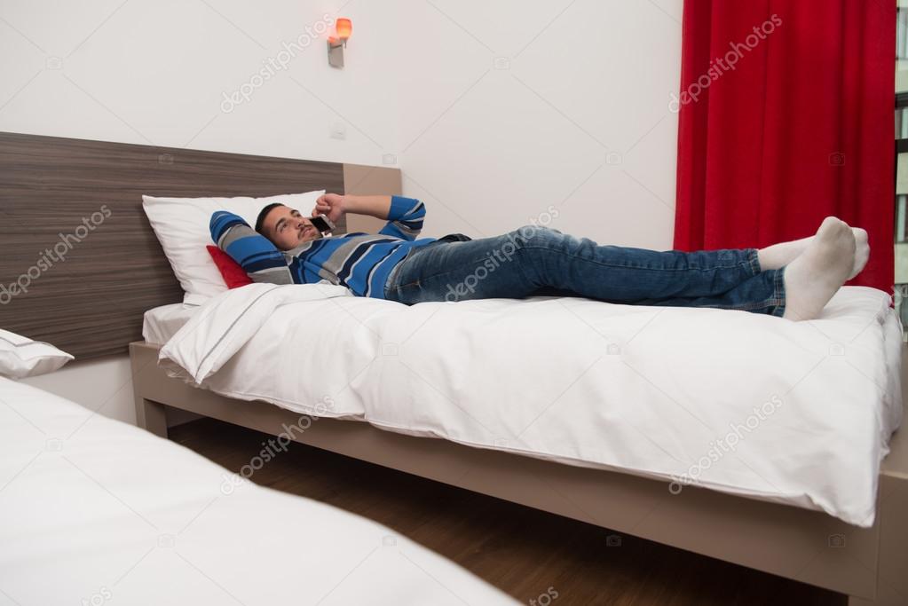 Student On Bed Using Phone
