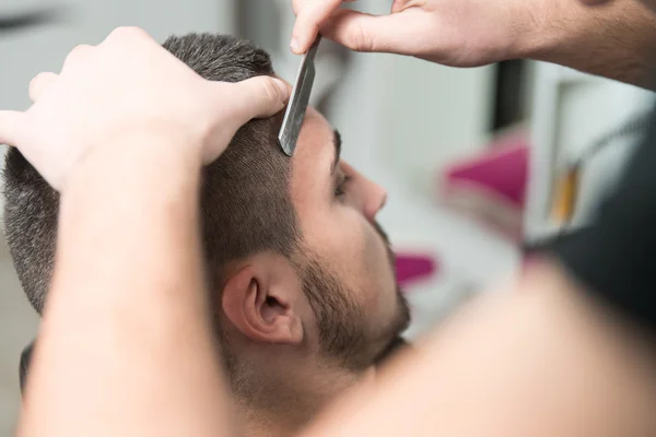 Cabeleireiro barbear o queixo do homem com uma navalha reta — Fotografia de Stock