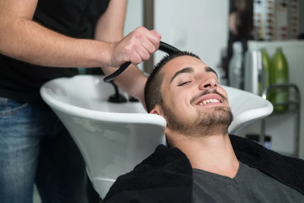 Портрет мужчины-клиента, которому вымывают волосы — стоковое фото