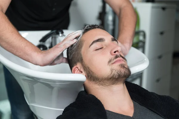 Portrait d'un client masculin se faisant laver les cheveux Images De Stock Libres De Droits