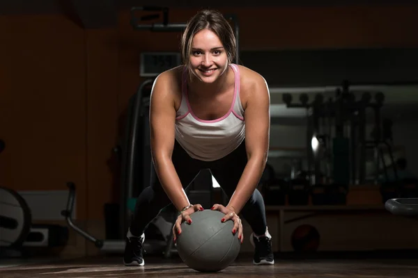 Junge Frau übt Liegestütze auf Medizinball — Stockfoto