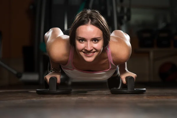 Ung kvinna utövar Push Ups på golvet — Stockfoto