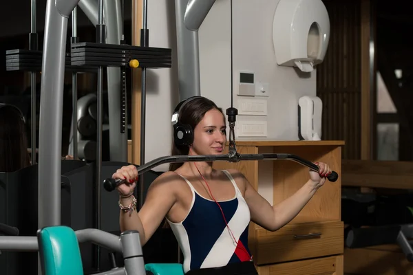 Ung kvinna gör ryggen övningar i gymmet — Stockfoto