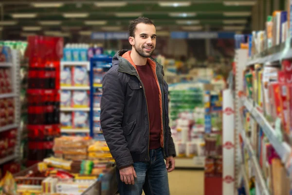 Guapo joven compras en un supermercado de comestibles —  Fotos de Stock