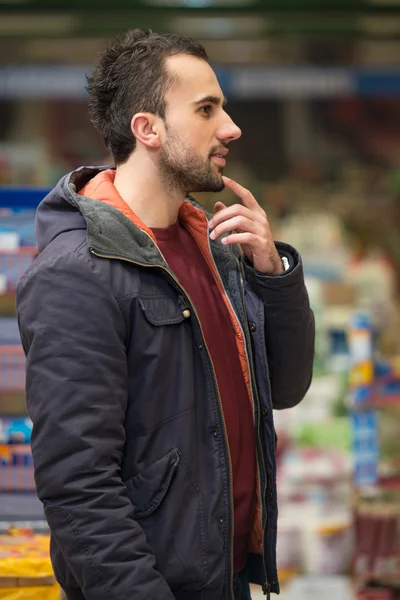Smuk ung mand shopping i en købmand supermarked - Stock-foto