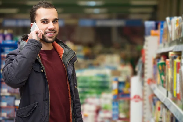 Handsome Man On Mobile Phone At Supermarket — Stock Photo, Image