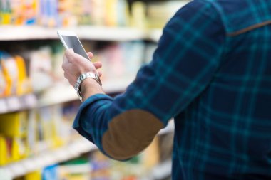 Hareket eden telefon alışveriş merkezi içinde bakarak adam