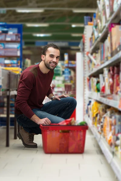 Csinos, fiatal férfi vásárlás egy élelmiszer-szupermarket — Stock Fotó
