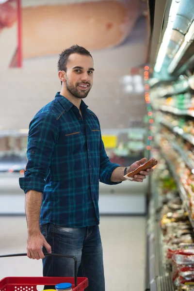 Genç adam süpermarkette alışveriş — Stok fotoğraf