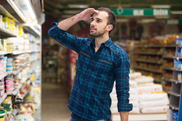 Homme confus faisant du shopping au supermarché — Photo