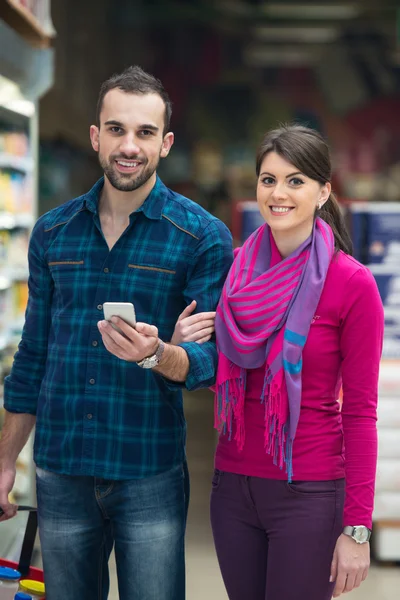 Улыбающаяся парочка покупает молочные продукты в супермаркете — стоковое фото
