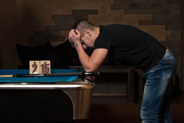 Joven buscando confundido en mesa de billar — Foto de Stock