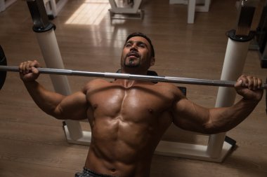Barbell ile göğüs için egzersiz yaparak vücut geliştirmeci