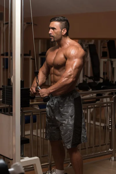 Мускулистый человек делает тяжелые упражнения веса для трицепсов — стоковое фото