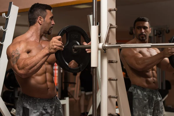 Bodybuilder sätta vikter på Bar i Gym — Stockfoto