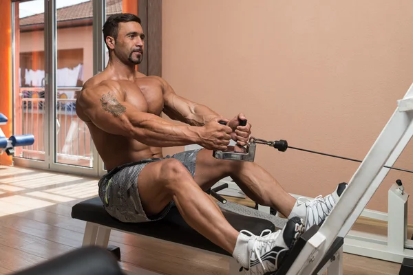 Hombre haciendo ejercicios de espalda en el gimnasio — Foto de Stock