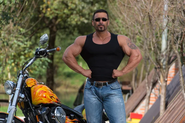 Bodybuilder en motorfiets — Stockfoto