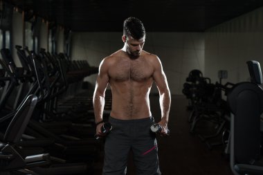 Egzersiz pazı Dumbbells ile genç adam
