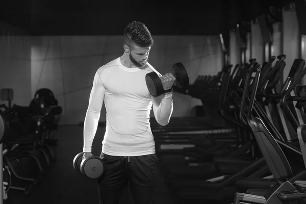 Jovem masculino fazendo exercícios de bíceps no ginásio — Fotografia de Stock