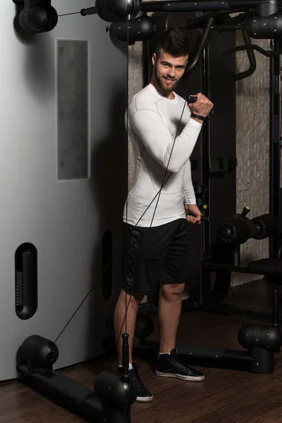 Young Man Exercising Biceps On Machine — Stock Photo, Image