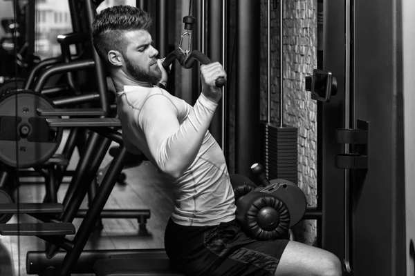 Jovem masculino fazendo exercícios nas costas no ginásio — Fotografia de Stock