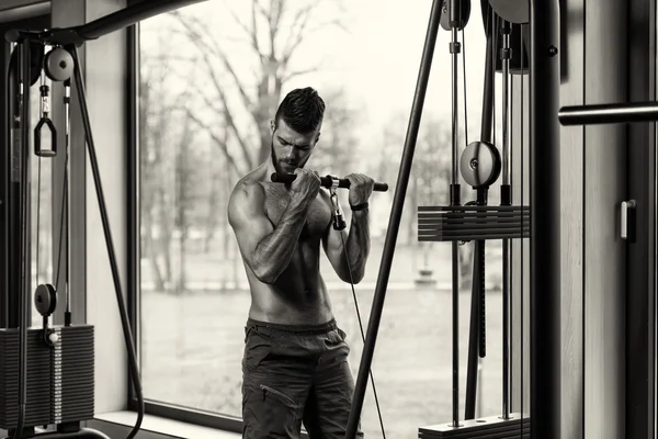 Jovem masculino fazendo exercícios de bíceps no ginásio — Fotografia de Stock