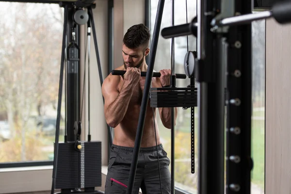 Ung man gör biceps övningar i gymmet — Stockfoto