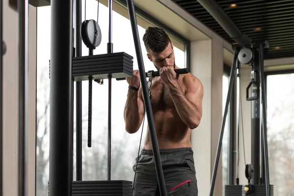 Молодой мужчина делает бицепсы упражнения в тренажерном зале — стоковое фото
