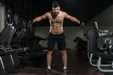 Yakışıklı adam omuz Dumbbells ile egzersiz