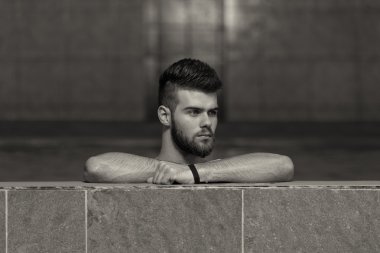 Havuzda dinlenen erkek yüzücü