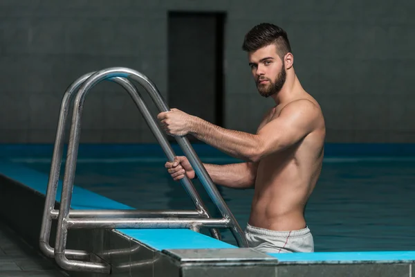 Jovem olhando o homem machista na piscina interior do hotel — Fotografia de Stock