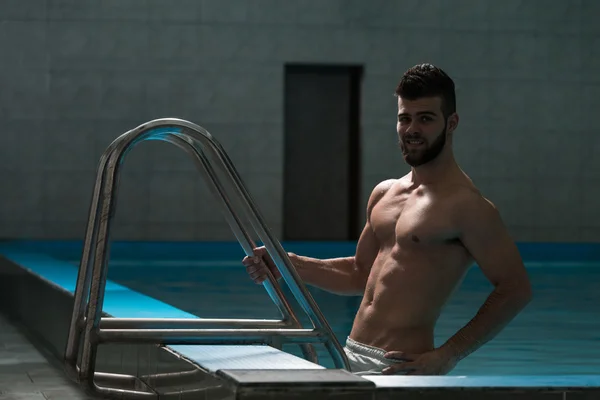 Jovem olhando o homem machista na piscina interior do hotel — Fotografia de Stock