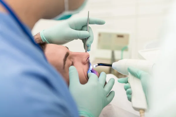 Крупный план открытого рта пациента во время орального осмотра — стоковое фото
