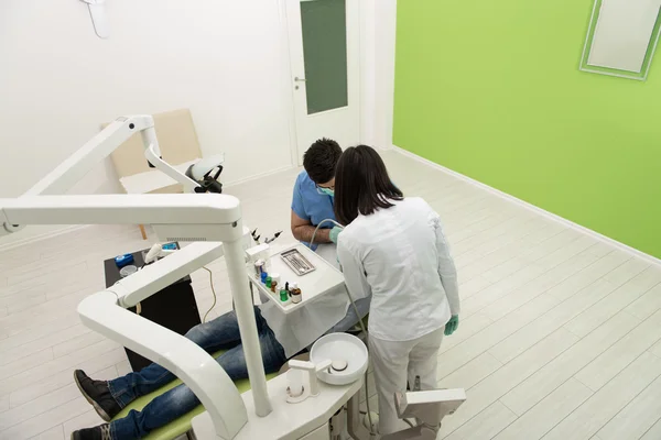 Tandläkaren gör en tandvård på Patient — Stockfoto