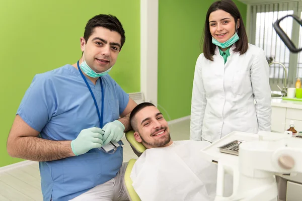 Portret van een tandarts, een assistent en een patiënt — Stockfoto