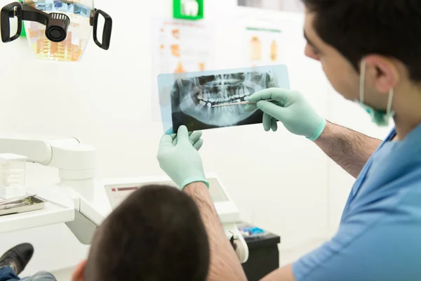 Tandarts Holding X-Ray en Examse wit patiënt — Stockfoto