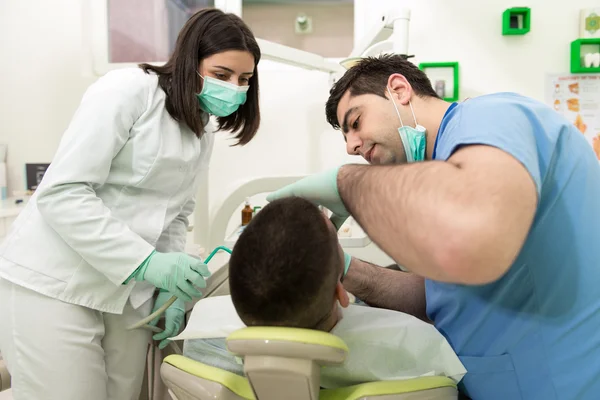 Zahnarzt heilt einen männlichen Patienten — Stockfoto