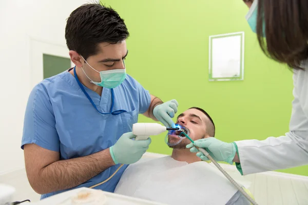 Tandläkare bota en manlig Patient — Stockfoto