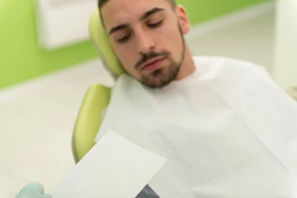 Tandläkare skriver på patientens personliga kortuppgifter — Stockfoto