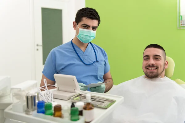 Dentista escribe en la tarjeta de información personal del paciente —  Fotos de Stock