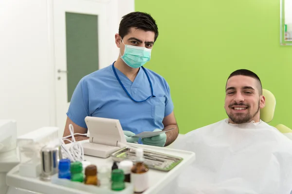 Tandarts schrijft op de patiënt persoonlijke kaartgegevens — Stockfoto