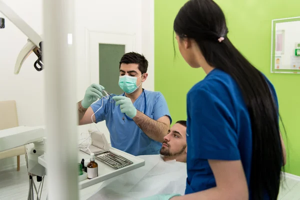 Dentista haciendo un tratamiento dental en el paciente — Foto de Stock