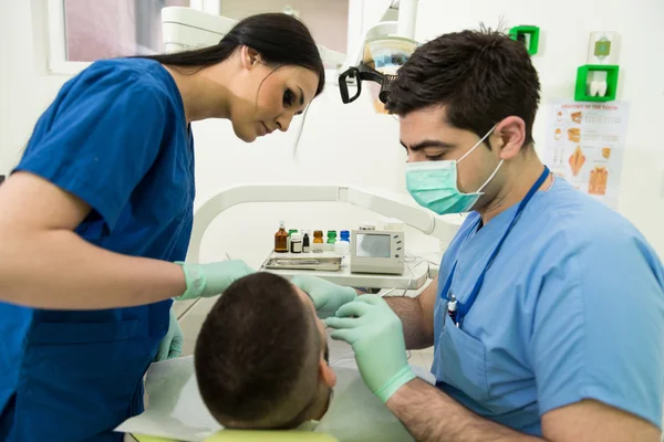 Dentista haciendo un tratamiento dental en el paciente —  Fotos de Stock