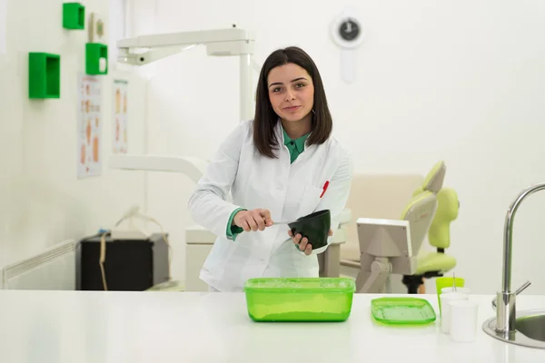 Joven dentista femenina trabajando en el molde —  Fotos de Stock