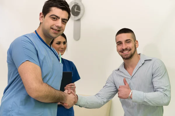 Tandarts feliciteer patiënt voor een succesvolle verrichting — Stockfoto