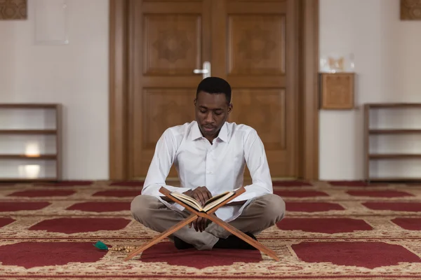 Junger afrikanischer Moslem liest den Koran — Stockfoto