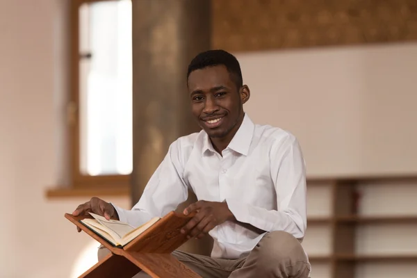 Hombre musulmán africano leyendo el Sagrado Libro Islámico Corán — Foto de Stock