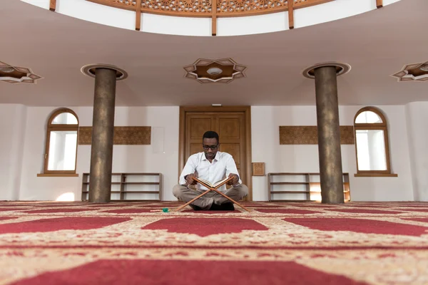アフリカのイスラム教徒の男性がコーランを読んでください。 — ストック写真