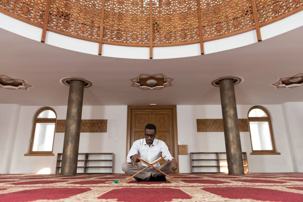 Unga afrikanska muslimska killen läser Koranen — Stockfoto