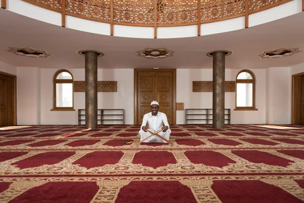 Afrikaanse moslim Man lezing islamitische heilige boek Koran — Stockfoto